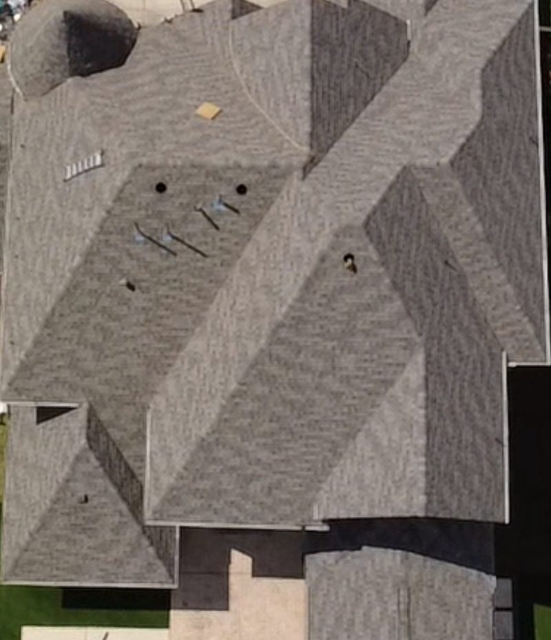 Drone view from above of a gray architectural shingle roof replacement by Built by Revitalize